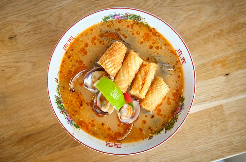 Appetizing soup with noodles and seafood on table