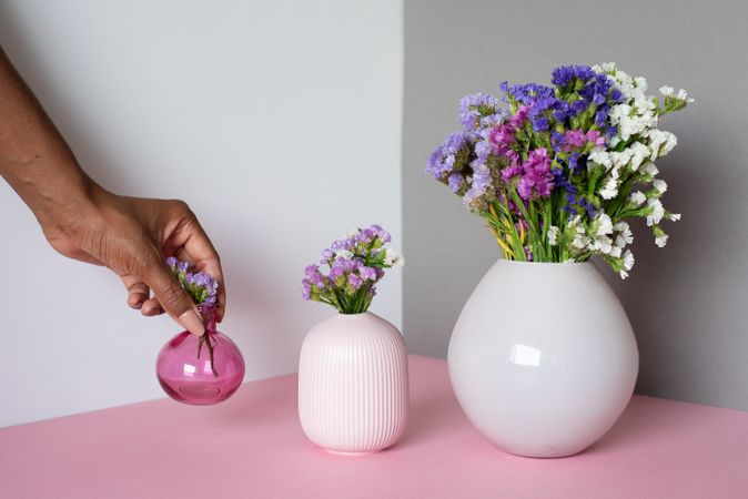 Hand fixing a vase of sea lavender flowers