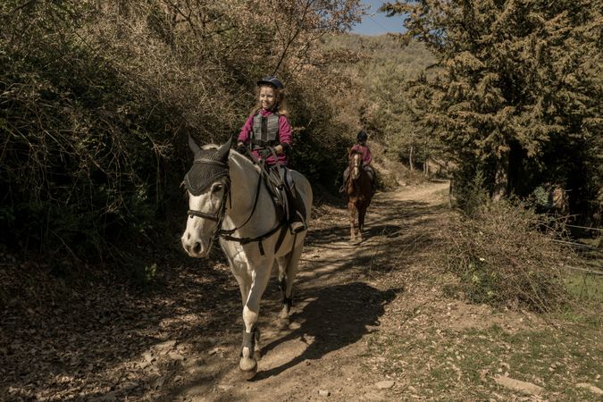 Anonymous people riding horses in brook