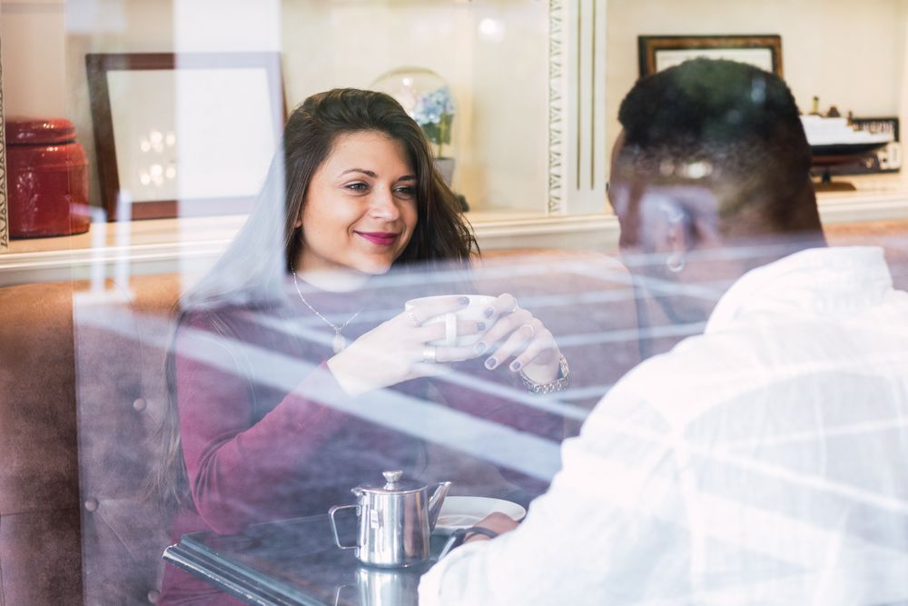 Multiracial couple chatting during breakfast in cafe