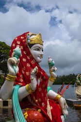 Red veiled Laksmi statue on lake