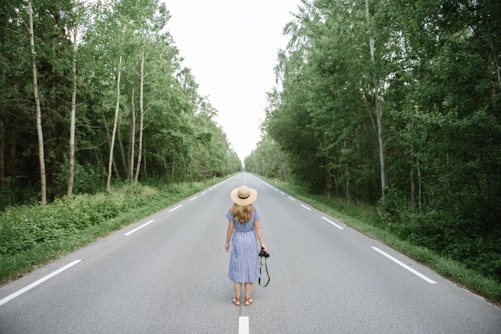 Young female photographer on forest road