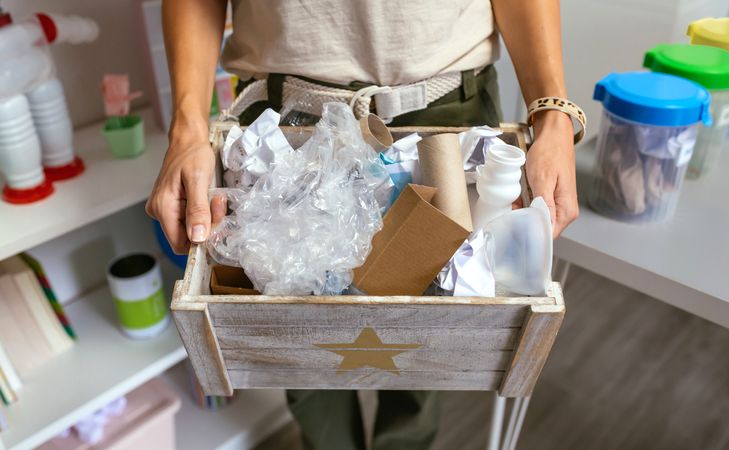 Female teacher showing a box of waste to recycle in ecology classroom