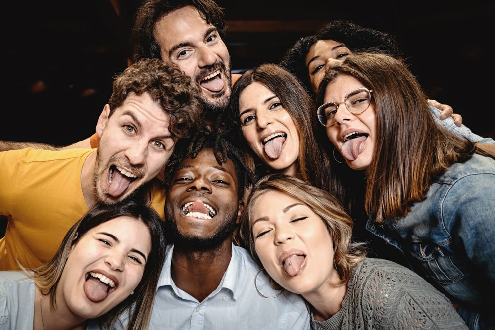 Portrait of happy friends embracing and making silly faces looking at the camera