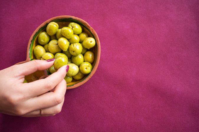 Asian woman eating olives in restaurant