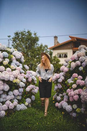 Positive woman among hydrangeas bushes