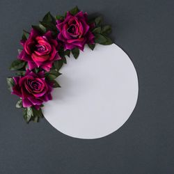 Purple flowers and leaves on gray background with paper card