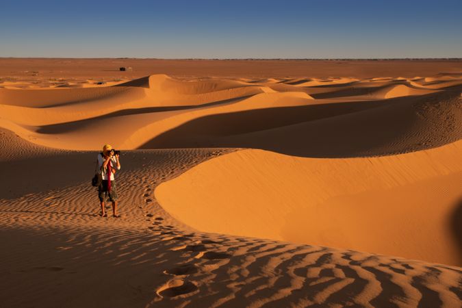 Anonymous photographer standing in desert