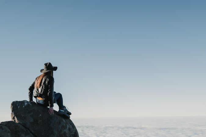 Woman sitting on rock in hillside
