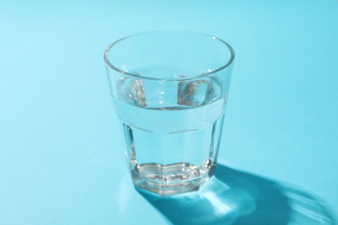 Full glass of water in blue room