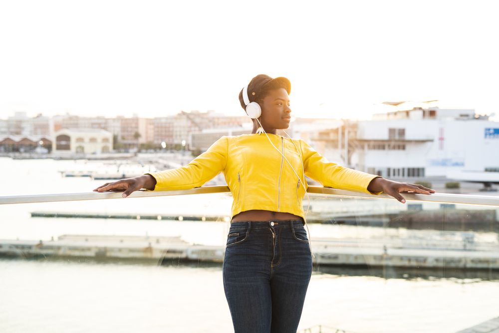 Peaceful female enjoying music and relaxing on balcony