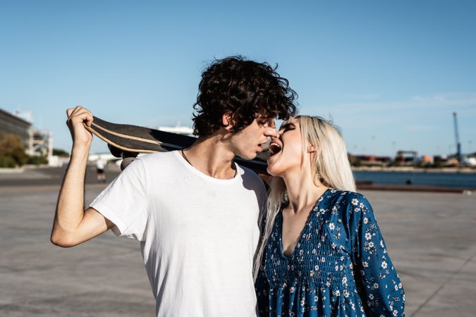 Trendy in love couple hugging on street