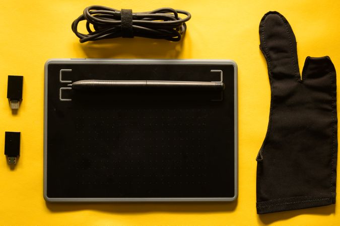 Digital tablet and accessories for graphic designer on yellow background
