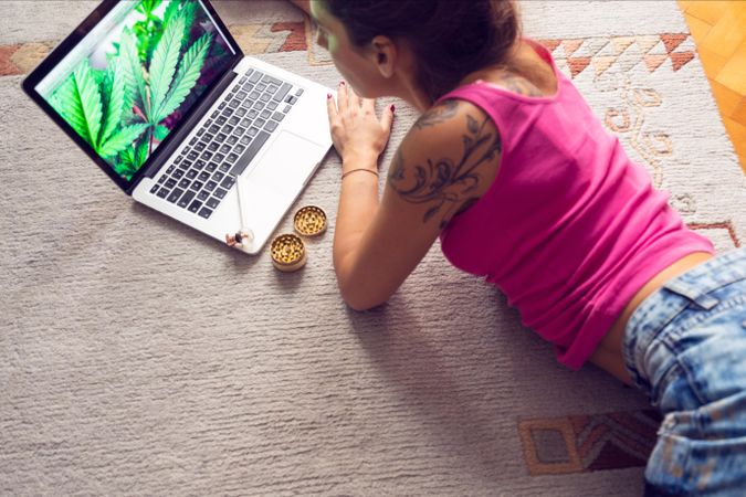 Woman at laptop with marijuana paraphernalia