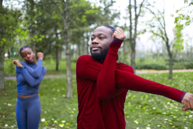 A young man and his companion stretching ahead of training