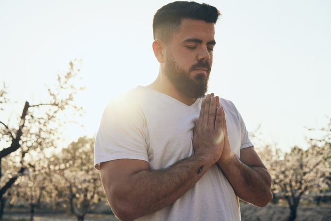 Bearded man meditating in spring garden