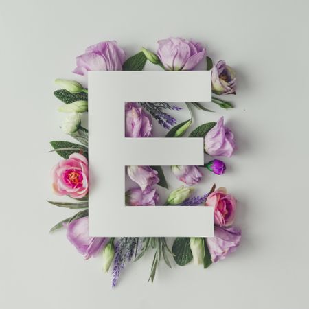 Colorful flowers, leaves and paper “E”