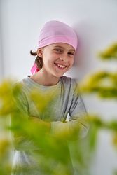 Smiling sick kid leaning on wall in clinic