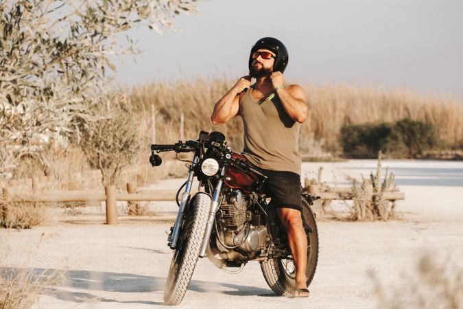 Serious male driving motorcycle in forest
