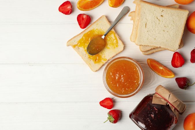 Composition with apricot jam on plain wooden background. Sweet breakfast