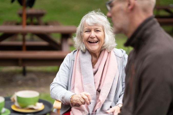 Happy woman enjoying tea while having a conversation with man