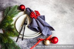 Christmas table setting with snowy pine branch, baubles and holly 0yknq4