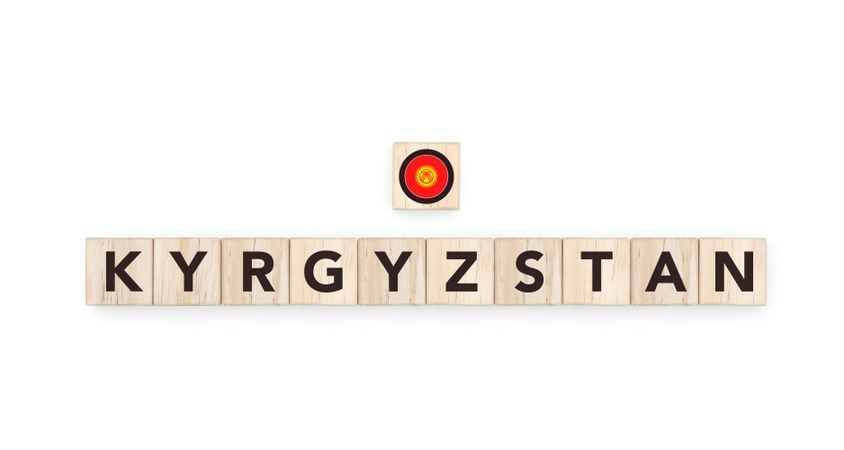 Wooden blocks bearing the name and flag of Kyrgyzstan. Kyrgyz and Asian Culture, national identity, travel, and geography in a copy space design.