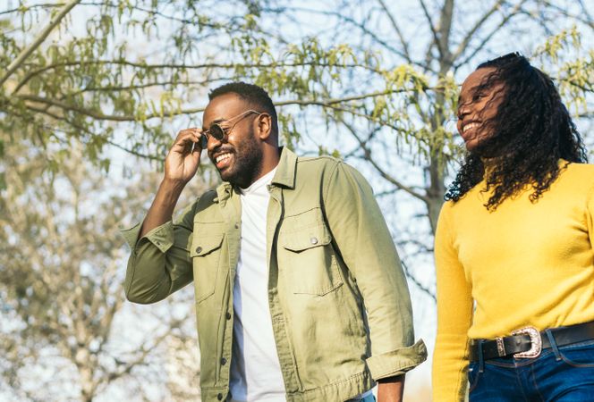 handsome Black young man and his sister walking in a park