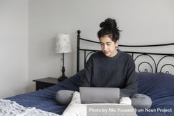 Young female working from her bed bGMAe5