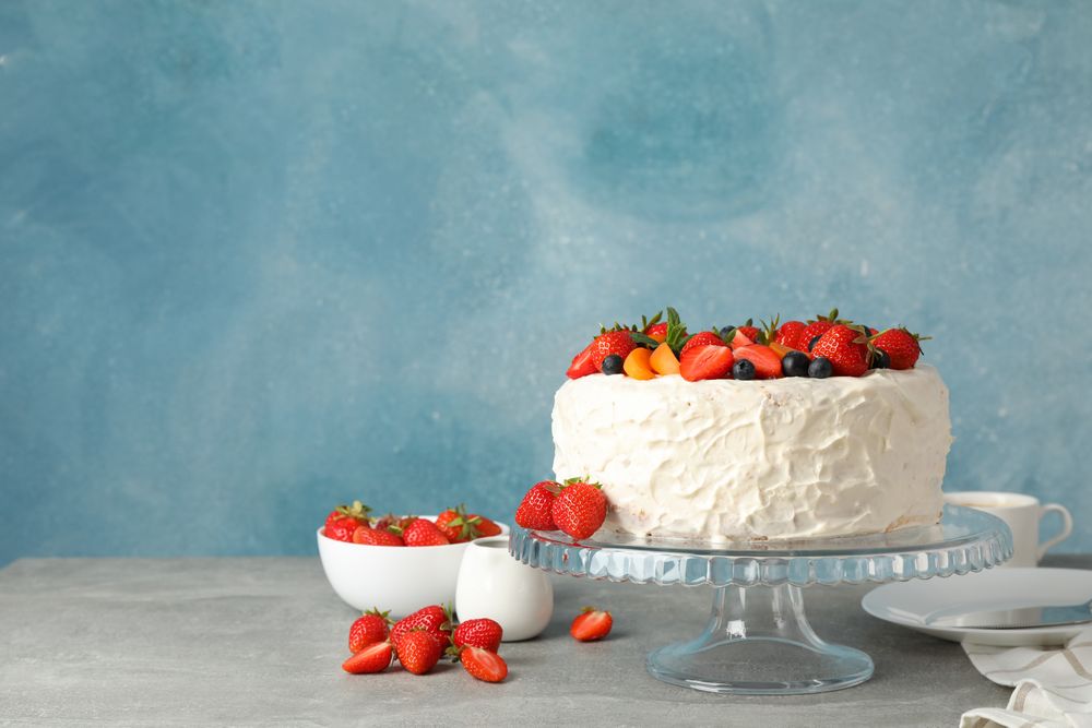 Composition with delicious berry cream cake on gray table. Tasty dessert