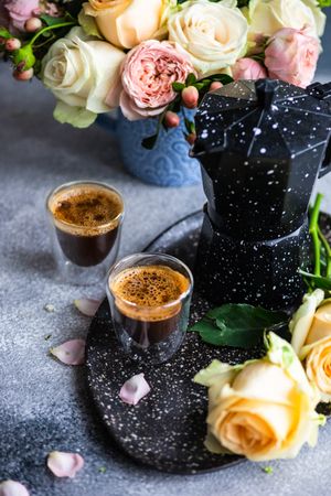 Two espressos with bouquet of roses and moka