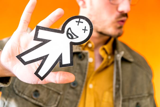 Smiling man holding funny paper toy