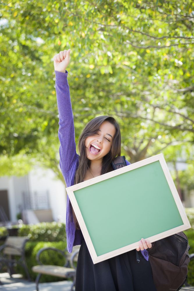 Happy Female Student Holding Blank Chalkboard