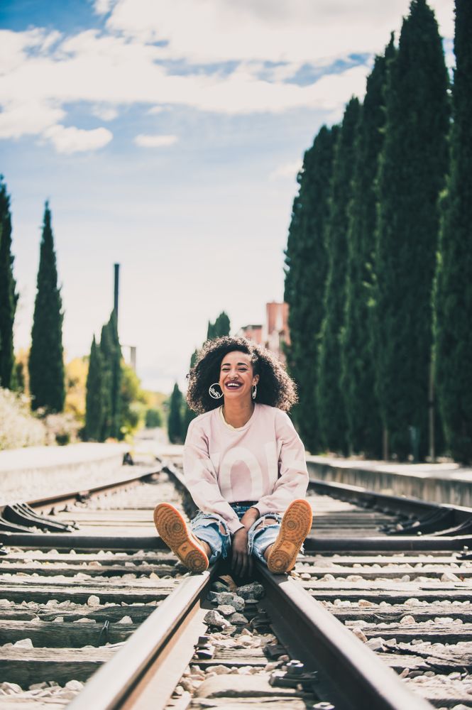 Black woman laughing in the tracks of a train