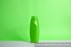 Green body wash bottle with no labels on counter with green background 4jVVdv