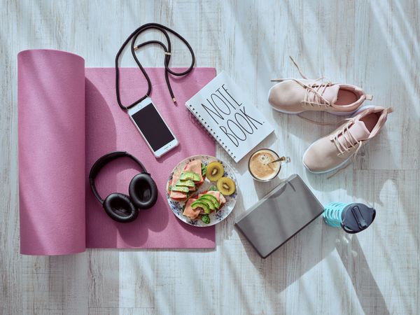 Fruits with smartphone and headphones on yoga mat