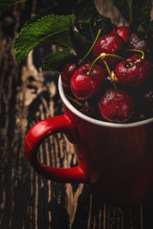 Cherry with branches in cup on table