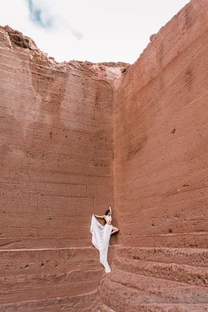 Elegant female posing on rocky cliff