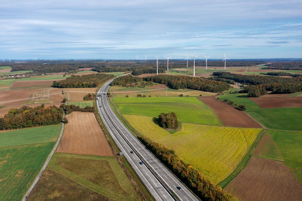Aerial shot with german highway and wind turbines in autumn scenery.