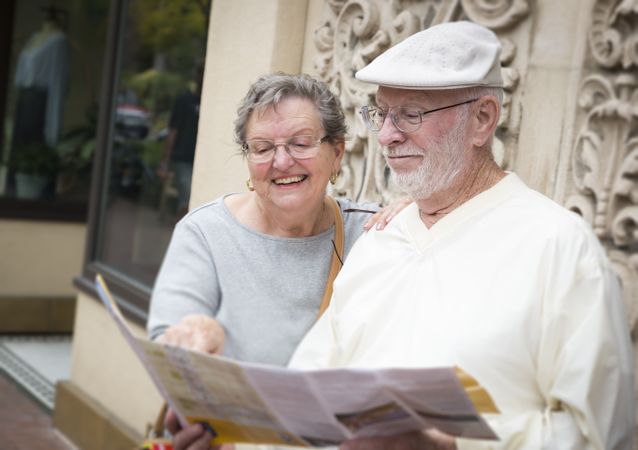 Tourist Couple Looking at Brochure Map