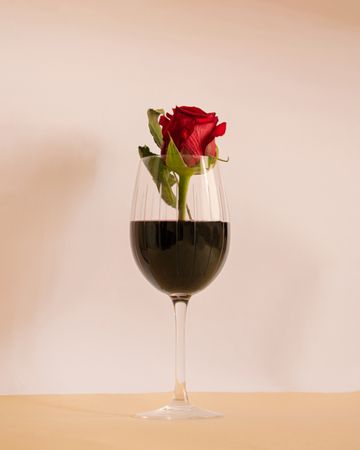 Centered glass of red wine with rose in it