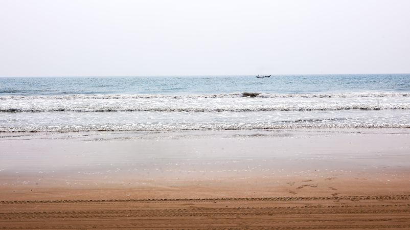 Calm ocean waves rolling onto an empty sandy beach