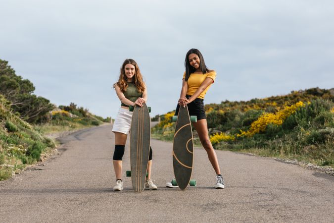 Cheerful diverse women walking on the road