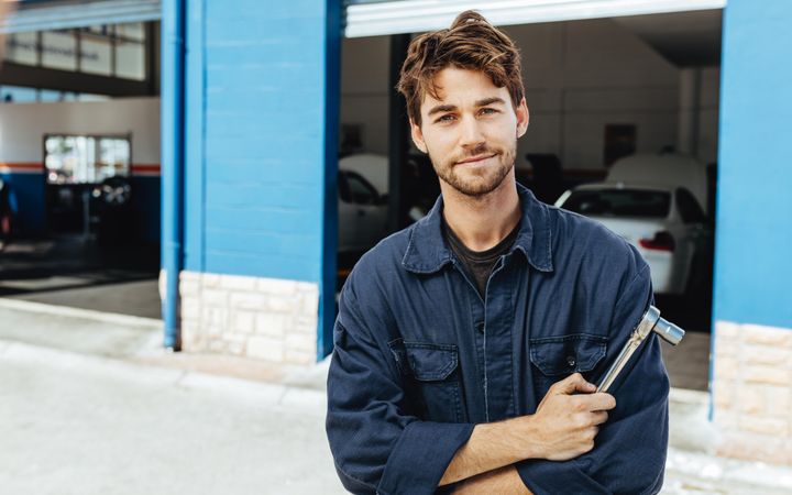 Portrait of a car mechanic in uniform with a spanner