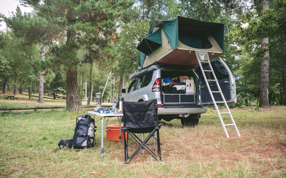 Offroad 4x4 vehicle with tent on roof ready for camping