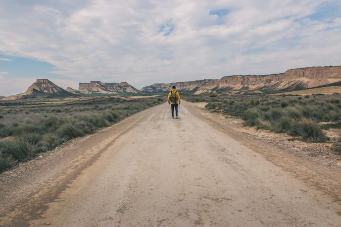 Man standing on road in desert hills