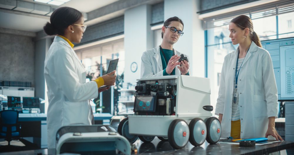Young Male and Female Engineers Discussing an Autonomous AI Delivery Assistant Prototype, Brainstorming