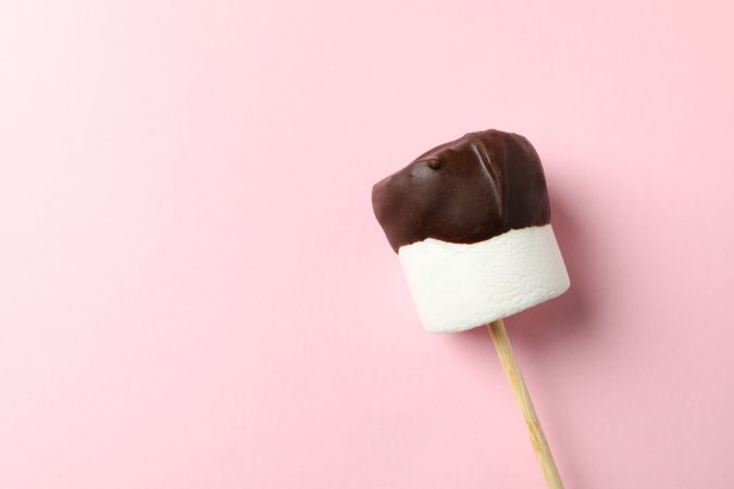Marshmallow in chocolate on pink background. Sweet food