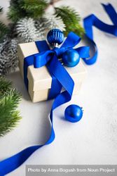 Christmas present with blue ribbon and baubles bGdPv0