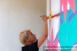 Blonde woman painting in colors on wall 41Y6j4